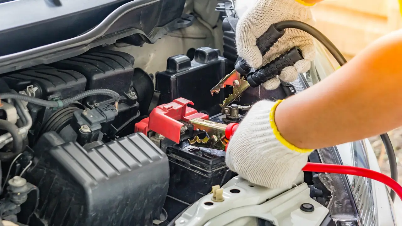 Car mechanic testing vehicle battery as part of the repair and maintenance process